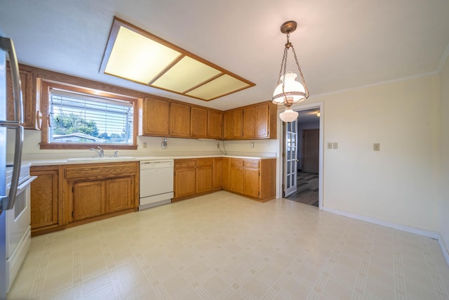 kitchen with crown molding, sink, white appliances, and decorative light fixtures