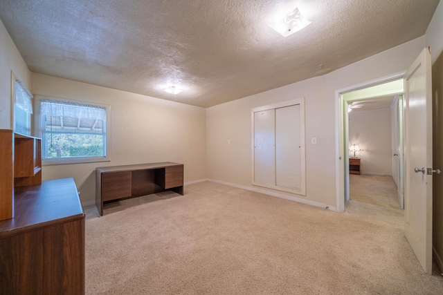 unfurnished bedroom with light colored carpet and a textured ceiling