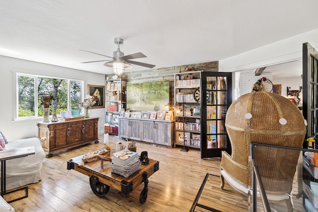 living room featuring ceiling fan and light wood-type flooring