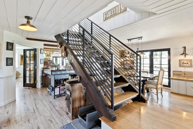 stairs with hardwood / wood-style floors and french doors