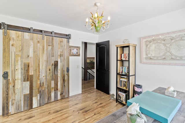 office space featuring a notable chandelier, wood-type flooring, and a barn door