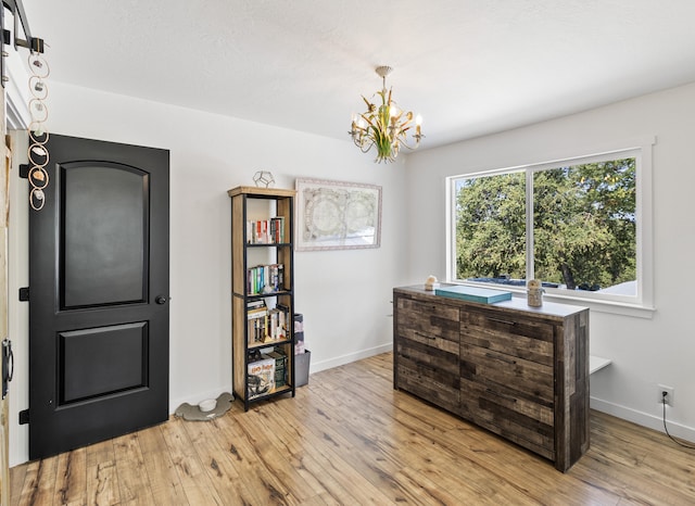 miscellaneous room with a notable chandelier and light hardwood / wood-style flooring