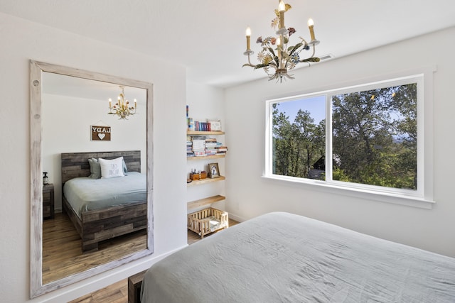 bedroom with hardwood / wood-style floors and a chandelier