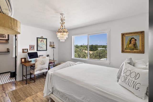 bedroom with hardwood / wood-style flooring and a chandelier