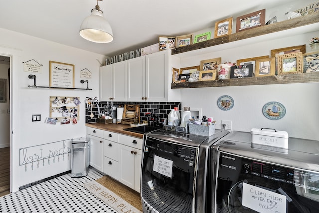 kitchen with butcher block counters, sink, independent washer and dryer, decorative backsplash, and white cabinets