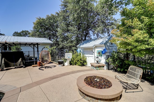 view of patio / terrace with an outbuilding, a fire pit, and a gazebo