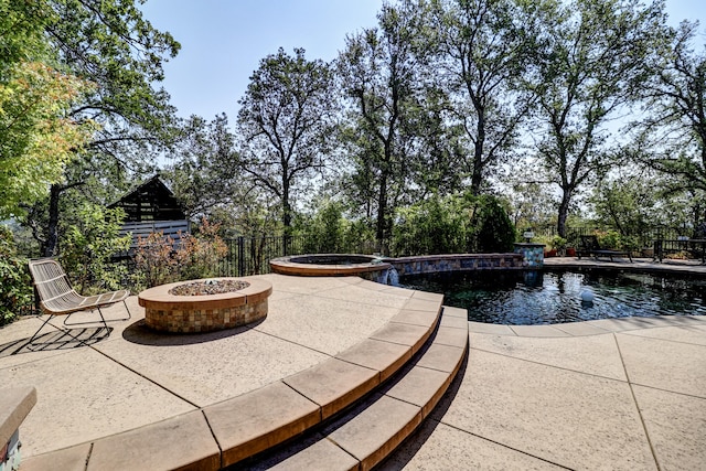 exterior space with an in ground hot tub, an outdoor fire pit, and a patio area