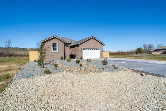 ranch-style house with driveway, a tiled roof, an attached garage, and stucco siding