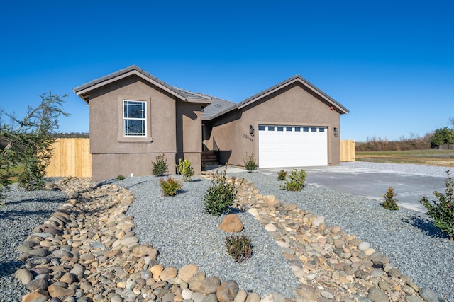 ranch-style home featuring driveway, a tiled roof, an attached garage, fence, and stucco siding