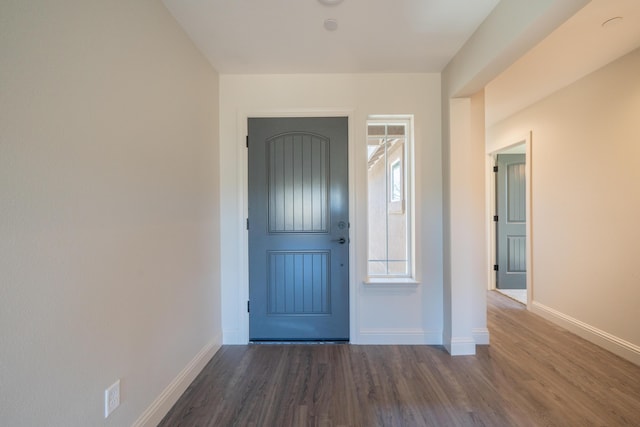 foyer with dark wood-style flooring and baseboards