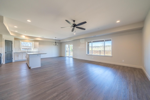 unfurnished living room with baseboards, dark wood finished floors, a ceiling fan, and recessed lighting