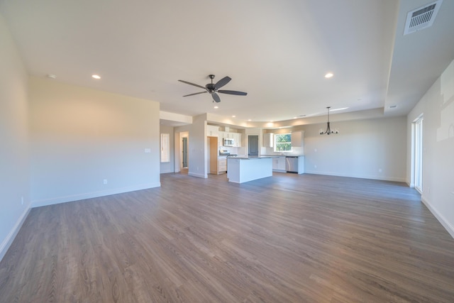 unfurnished living room with visible vents, dark wood finished floors, and ceiling fan with notable chandelier