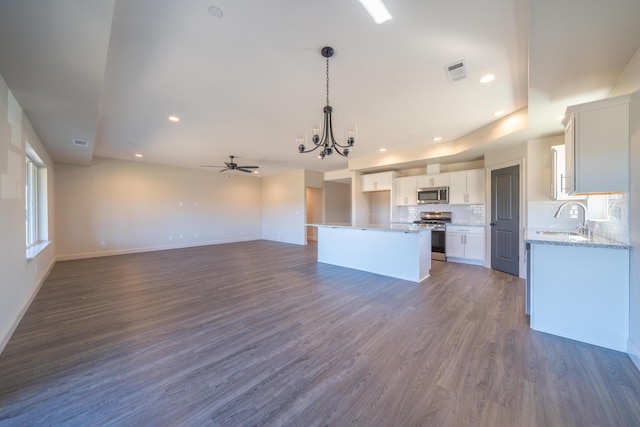 kitchen with visible vents, white cabinets, appliances with stainless steel finishes, open floor plan, and a center island