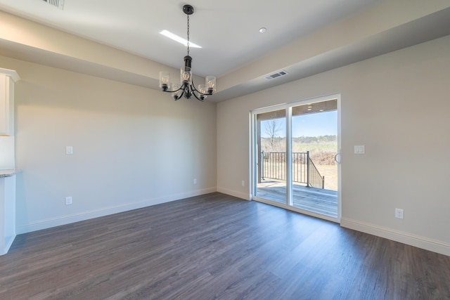 unfurnished room featuring dark wood-style floors, baseboards, visible vents, and an inviting chandelier