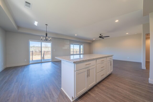 kitchen featuring a kitchen island, white cabinets, open floor plan, dark wood finished floors, and pendant lighting