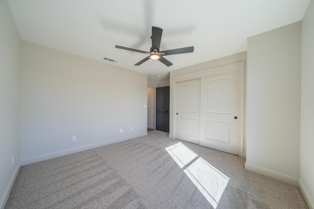 unfurnished bedroom with light carpet, baseboards, visible vents, ceiling fan, and a closet