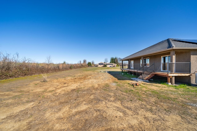 view of yard featuring a deck and stairs