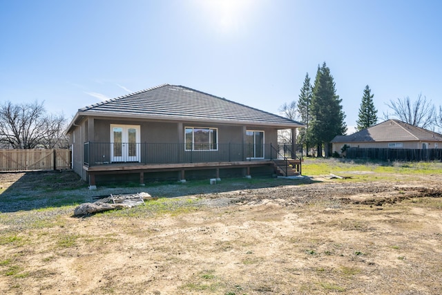 back of house with french doors, fence, and a wooden deck