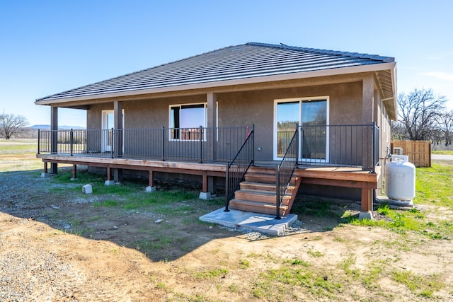 rear view of house featuring a porch and stucco siding