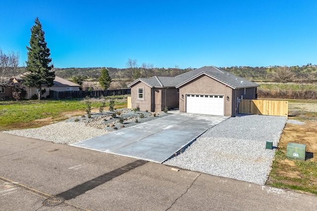 single story home with a garage, fence, driveway, a tiled roof, and stucco siding