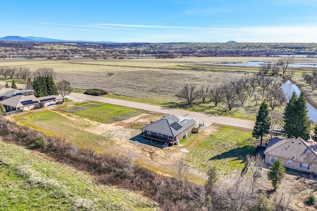 drone / aerial view featuring a rural view and a water and mountain view