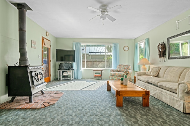 carpeted living room featuring ceiling fan and a wood stove