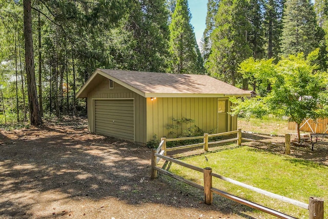 view of shed / structure with a garage and a yard