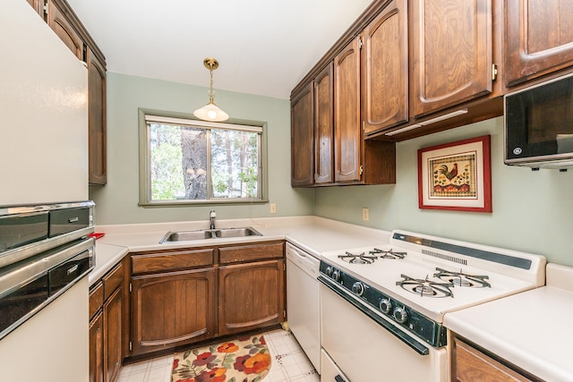 kitchen with decorative light fixtures, sink, white appliances, and light tile floors