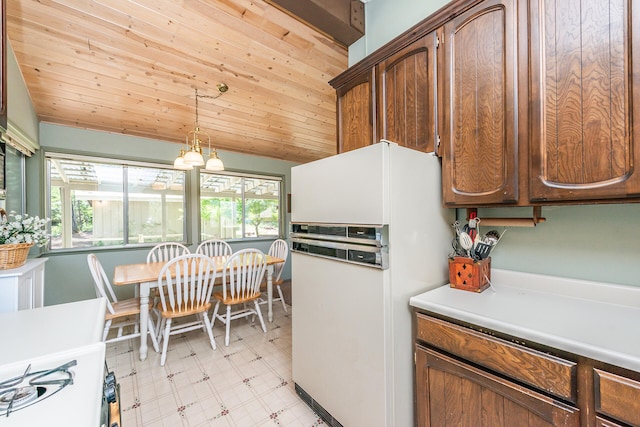 kitchen featuring decorative light fixtures, wooden ceiling, white fridge, and plenty of natural light