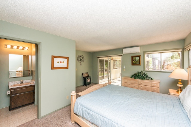 bedroom with a textured ceiling, light carpet, access to outside, a wall mounted AC, and sink