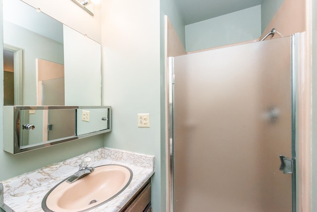 bathroom with a shower with shower door and vanity