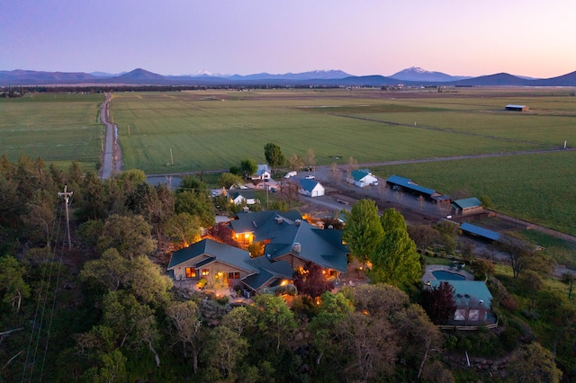 aerial view at dusk with a mountain view and a rural view