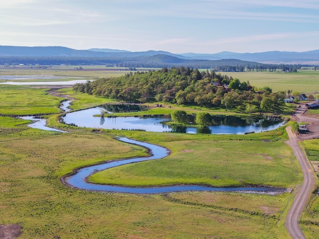 birds eye view of property featuring a water and mountain view and a rural view