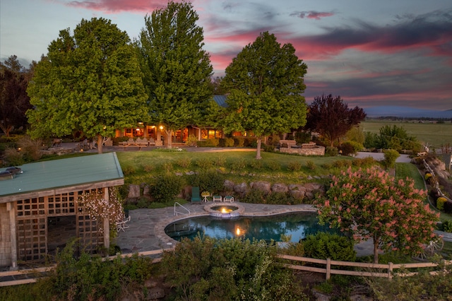 pool at dusk featuring a patio area