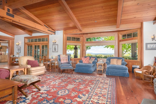 living room featuring wood-type flooring, vaulted ceiling with beams, and plenty of natural light