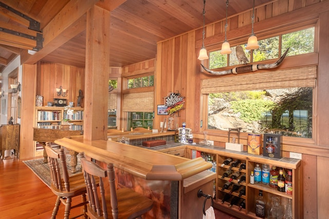 bar with wood ceiling, wood walls, wood-type flooring, and a wealth of natural light