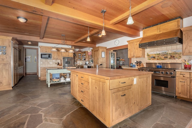 kitchen with butcher block counters, appliances with stainless steel finishes, beam ceiling, and a center island with sink