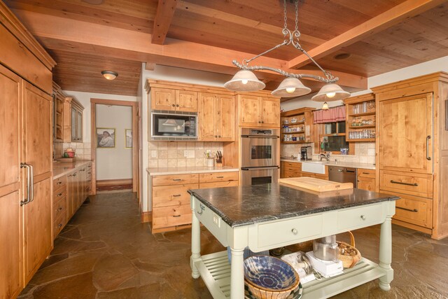 kitchen with a kitchen island, appliances with stainless steel finishes, backsplash, and beam ceiling