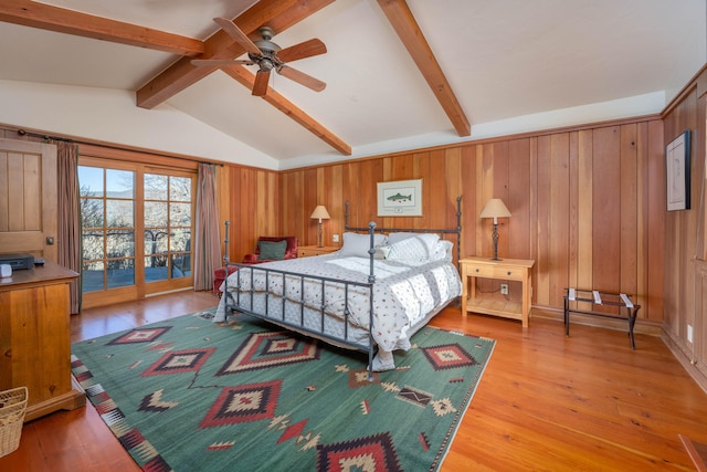 bedroom featuring light hardwood / wood-style floors, lofted ceiling with beams, and access to exterior