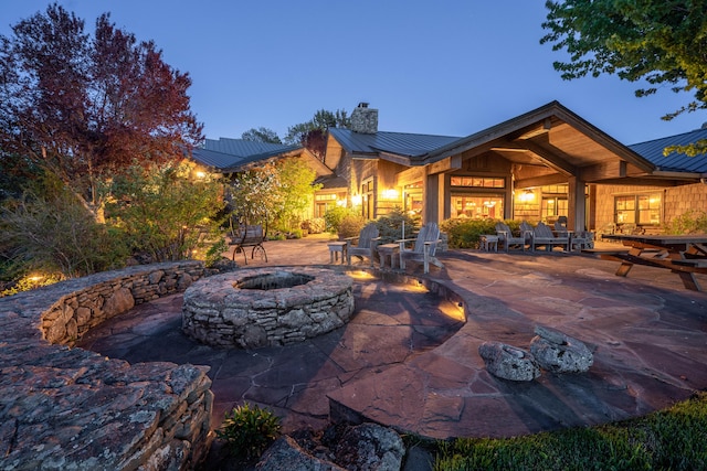 back of property featuring a patio and an outdoor fire pit