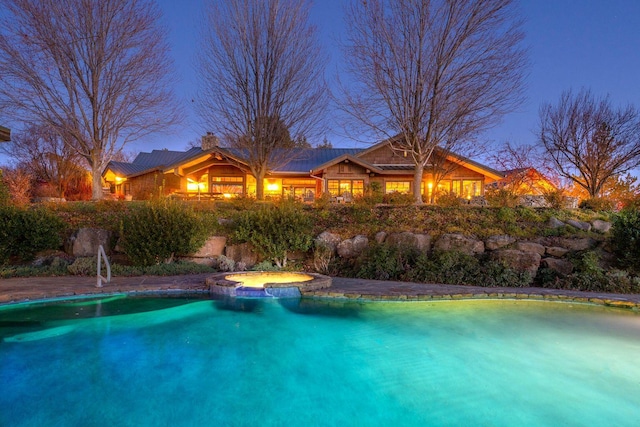 view of pool at dusk