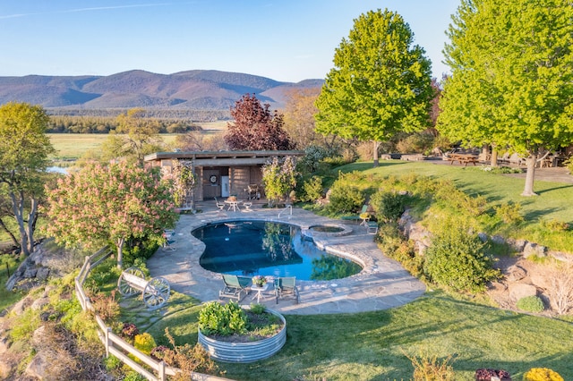 view of swimming pool with a mountain view, a patio area, and a yard