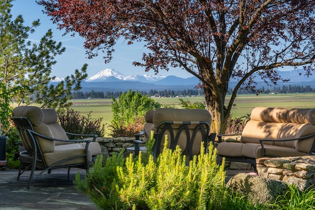 view of patio with a mountain view, an outdoor living space, and a rural view