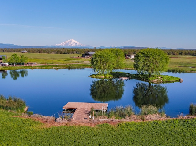 water view with a boat dock, a mountain view, and a rural view