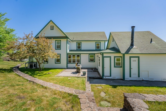 rear view of house featuring a patio and a yard