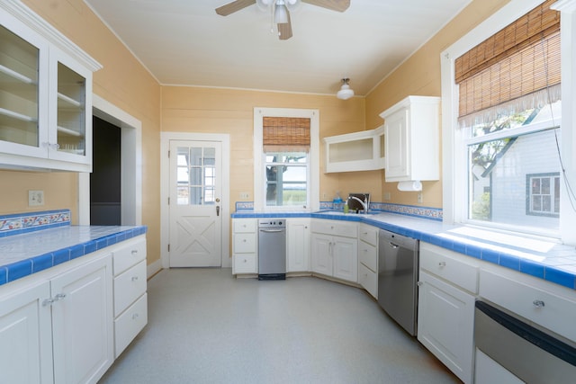 kitchen featuring dishwasher, ceiling fan, tile countertops, and white cabinets