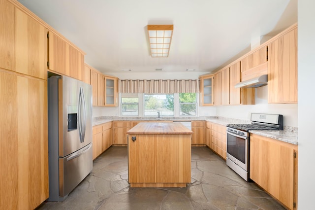 27744 Lee Rd, Mcarthur, CA 96056 - kitchen featuring stone tile floors, a center island, light brown cabinetry, under cabinet range hood, and appliances with stainless steel finishes