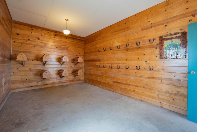 empty room with concrete floors and wooden walls