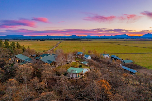 aerial view at dusk with a mountain view and a rural view