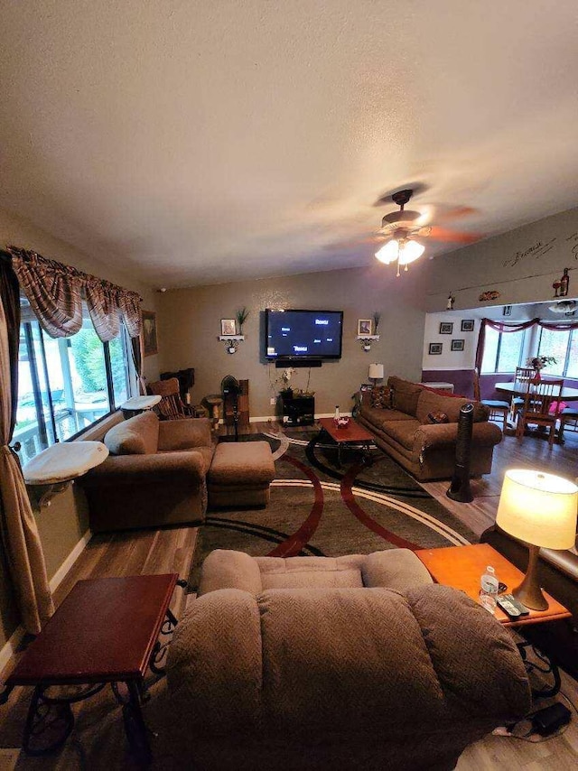 living room with hardwood / wood-style floors, ceiling fan, and plenty of natural light